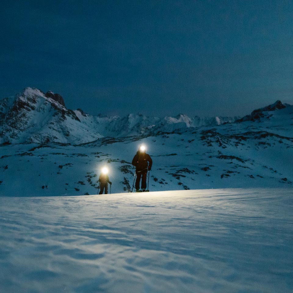 Two people ski touring in a winter landscape