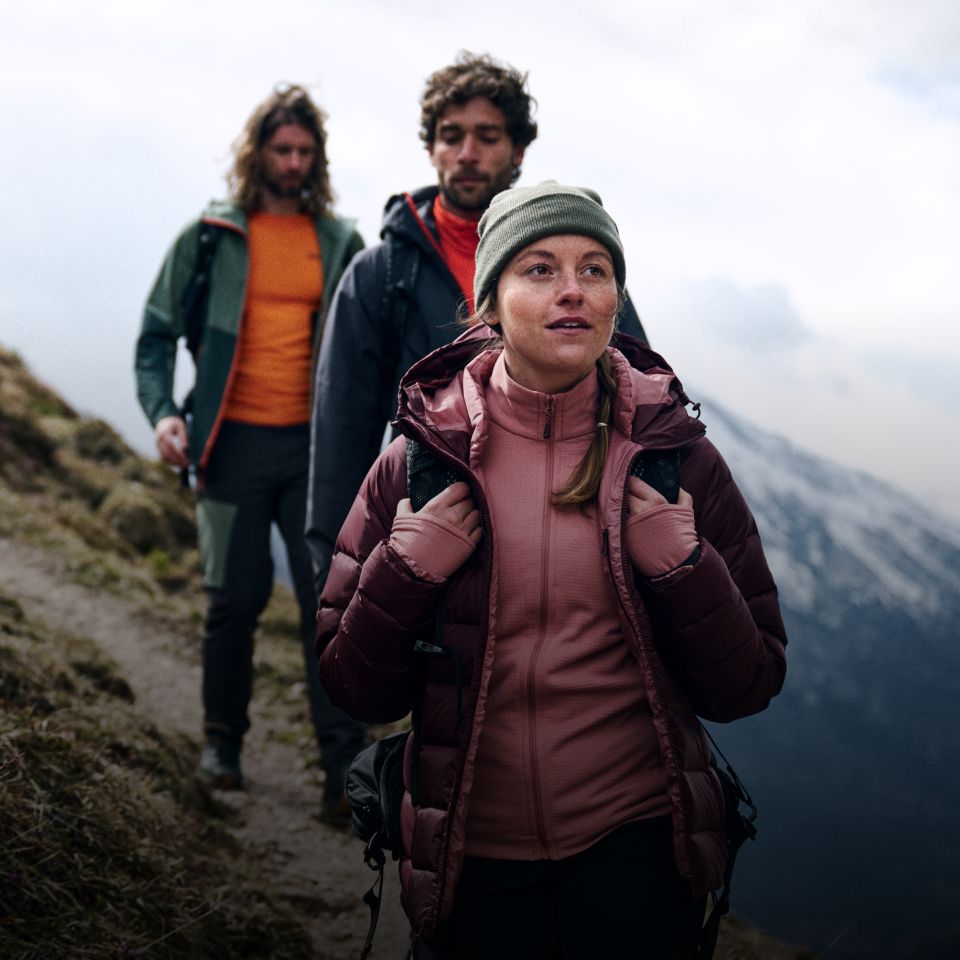 Three hikers in warm clothing hiking on a mountain